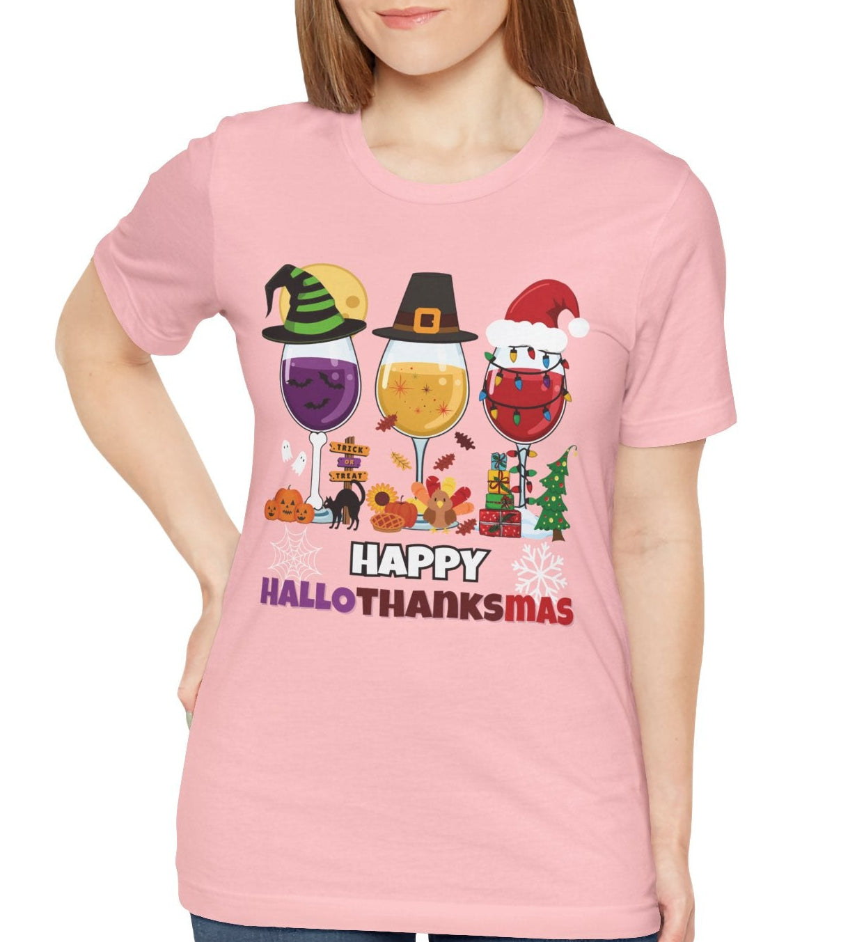 Person wearing a pink t-shirt with 'Happy HalloTHANKsmas' design on a white background