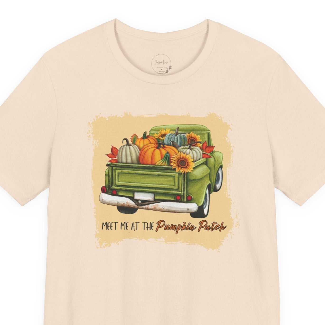 Beige t-shirt with a graphic of a green truck and pumpkins on a white background