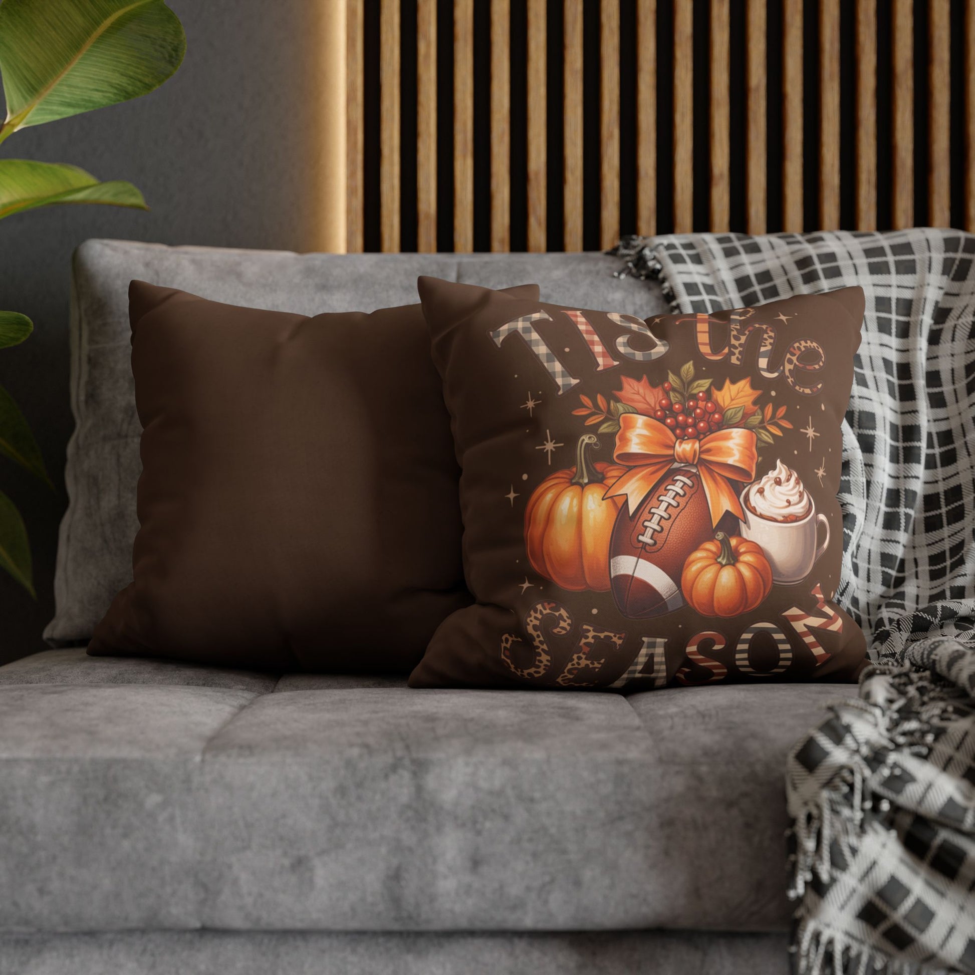 Decorative pillows on a gray sofa with a plaid blanket, featuring autumn-themed designs.