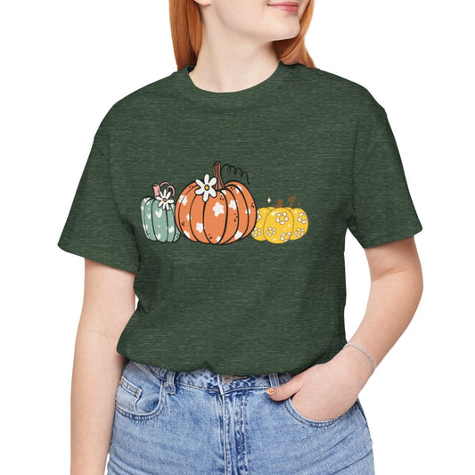 Person wearing a green t-shirt with pumpkin design on a white background