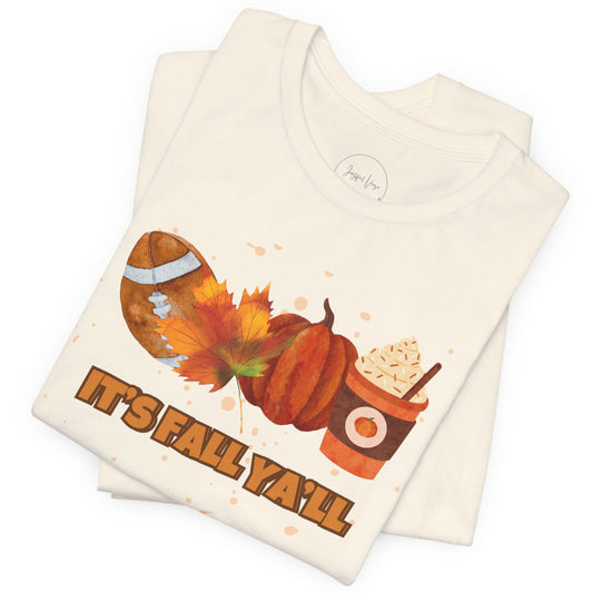 Folded cream colored t shirt with autumn-themed design and text 'It's Fall Ya'll' on a white background