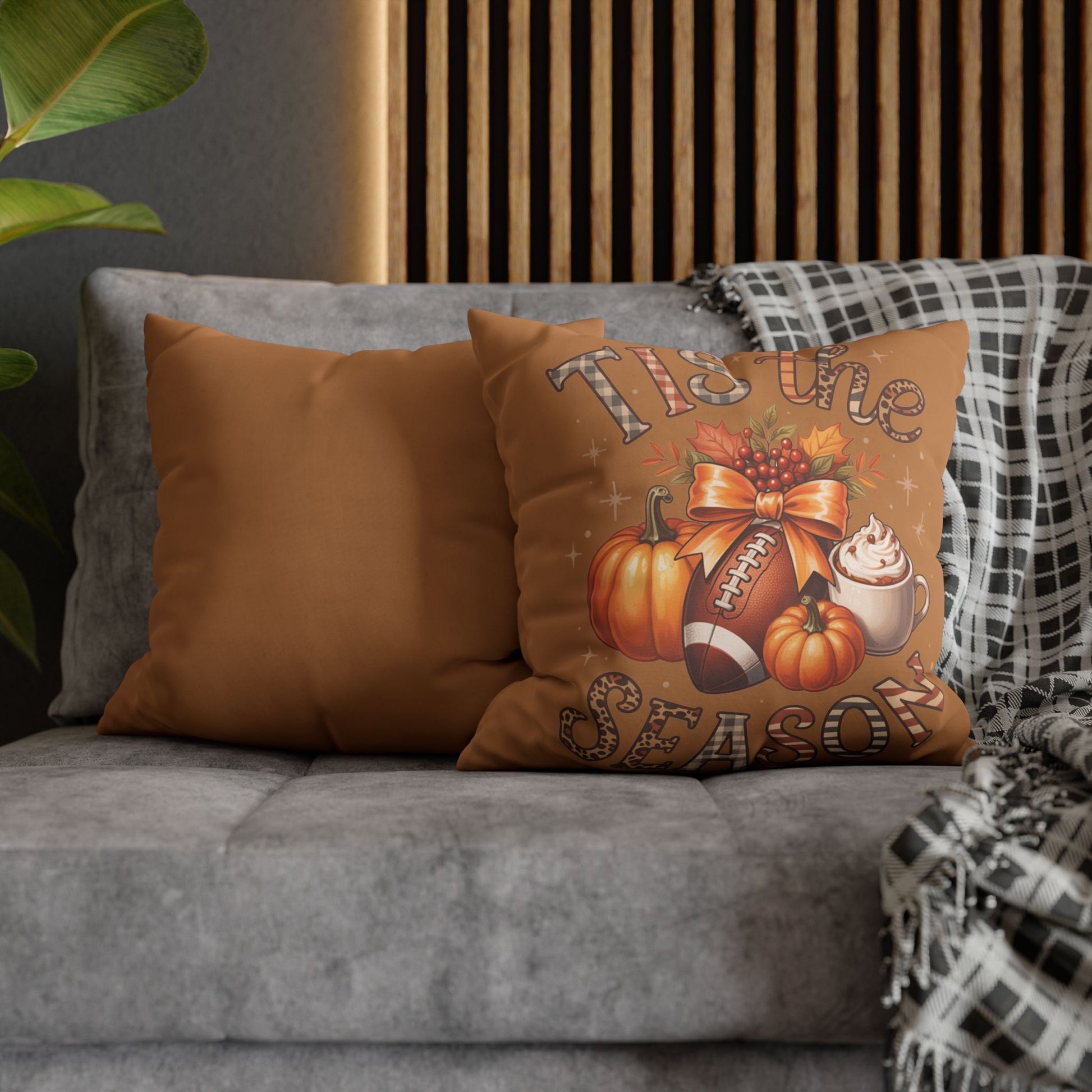 Decorative pillow with autumn-themed design on a gray sofa.