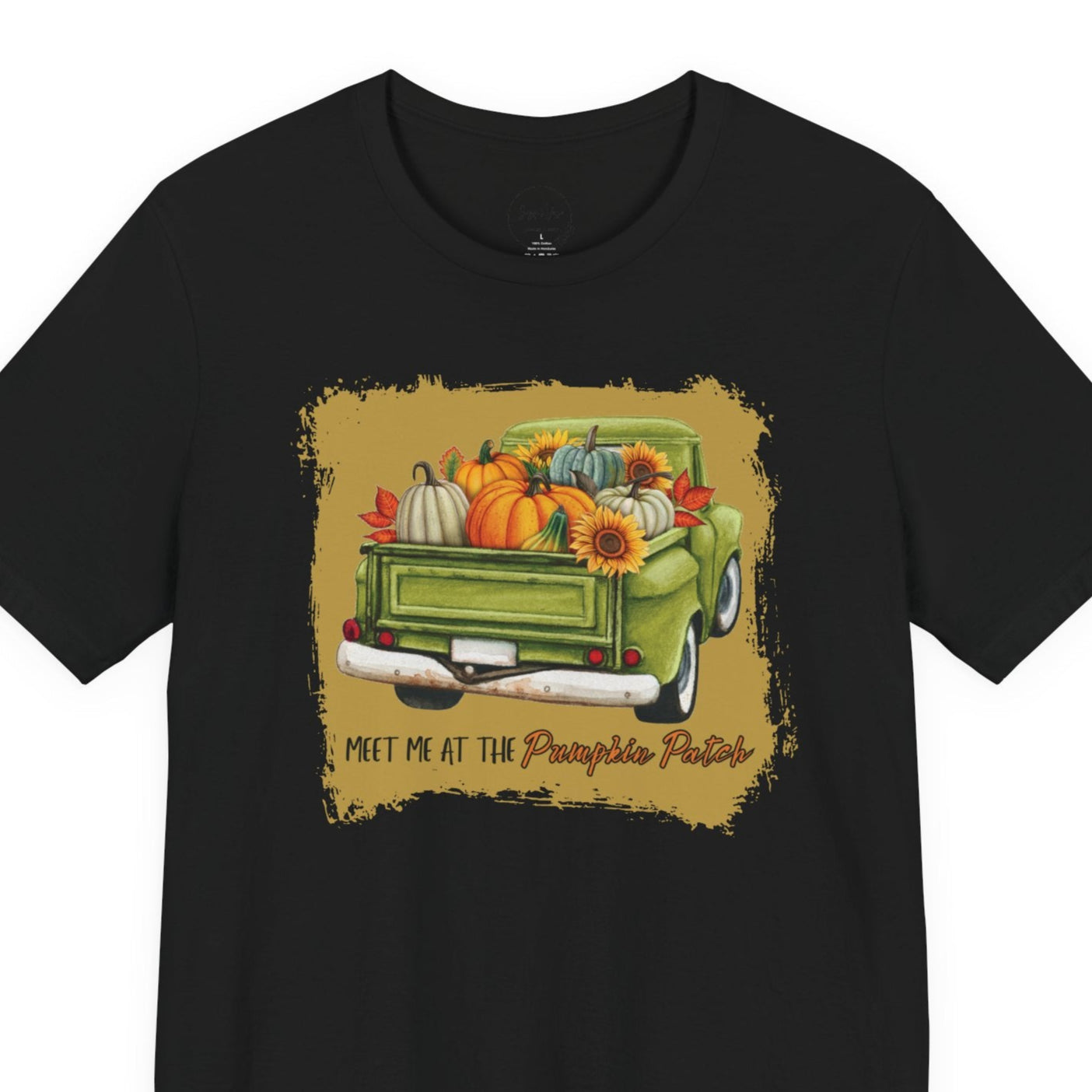 Black t-shirt with a graphic of a green truck carrying pumpkins and sunflowers, with text 'Meet me at the Pumpkin Patch' on a white background.