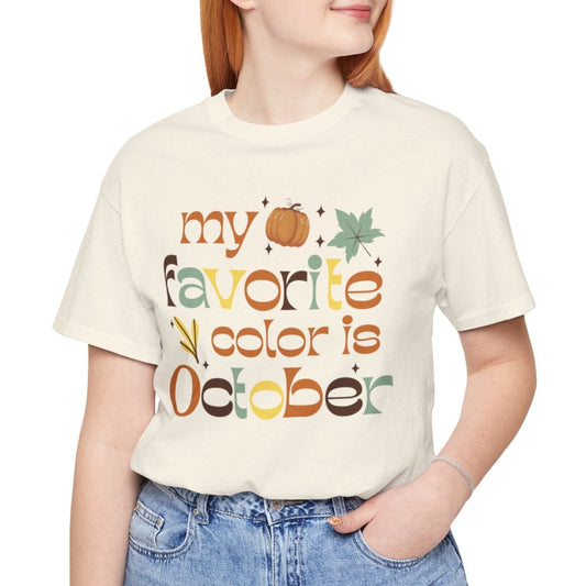 Person wearing a cream t-shirt with 'my favorite color is October' text and graphics.