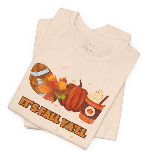 Folded beige t-shirt with autumn-themed design and 'It's Fall Ya'll' text on a white background