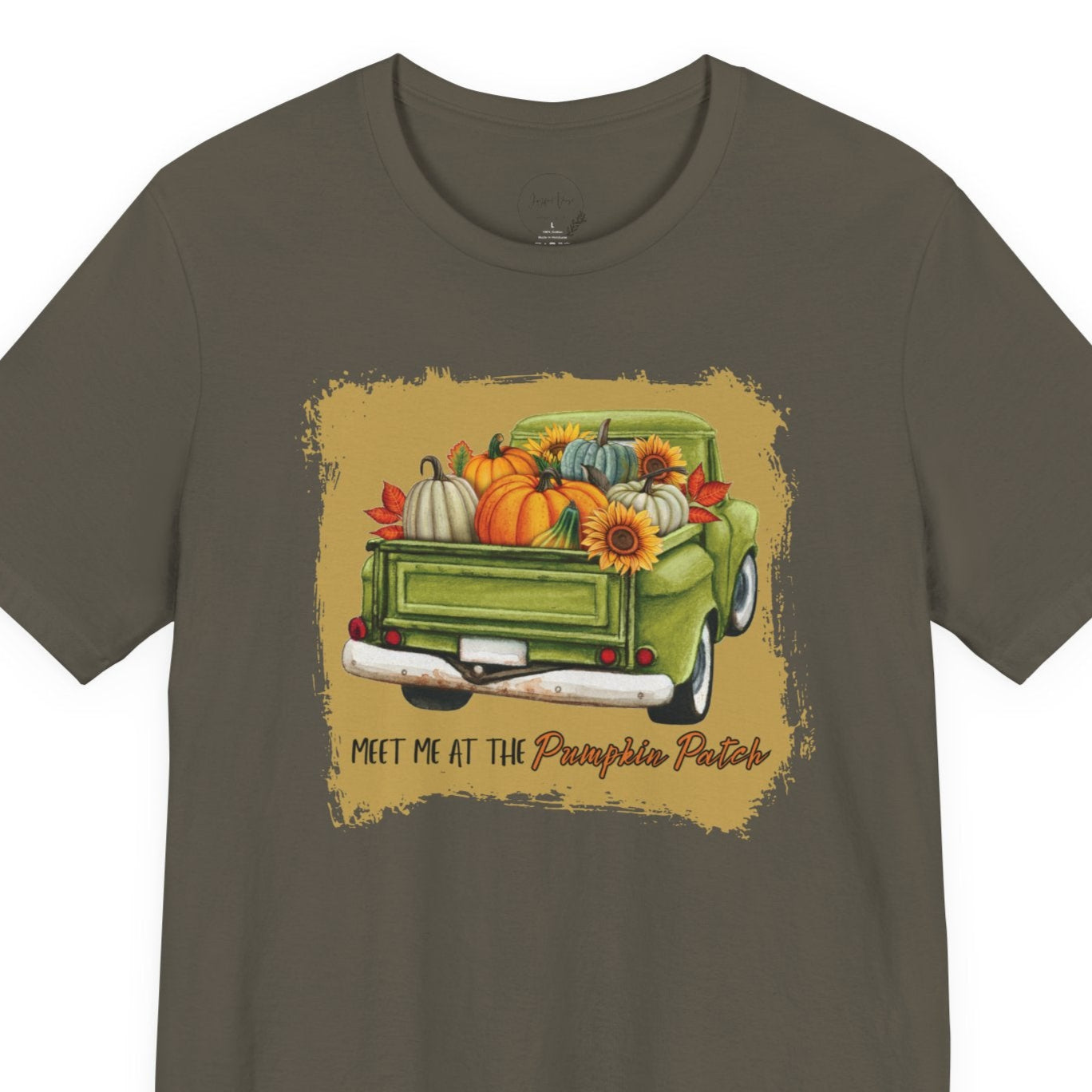 Green t-shirt with a graphic of a truck carrying pumpkins and gourds on a beige background.