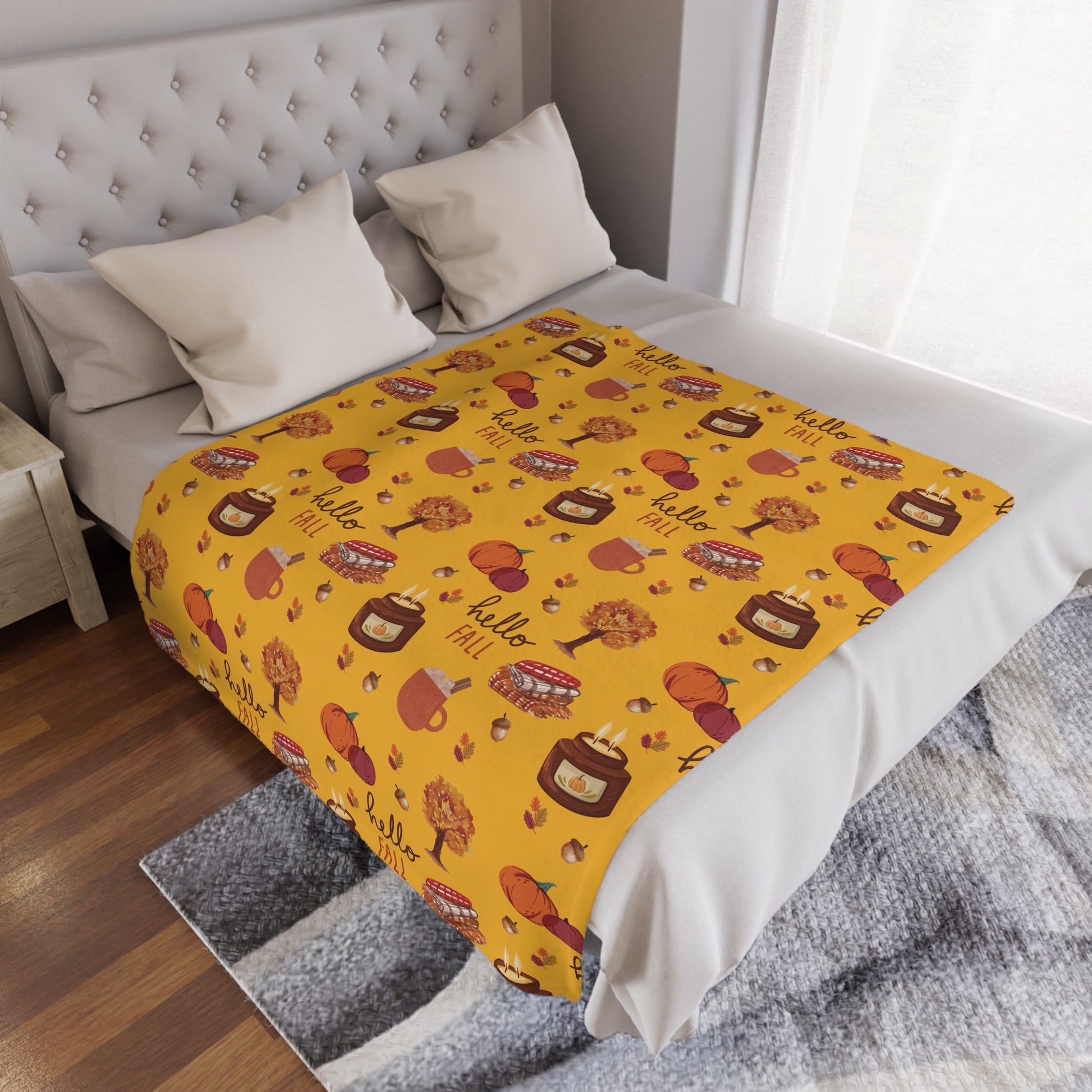 Yellow minky blanket with autumn-themed pattern on a bed