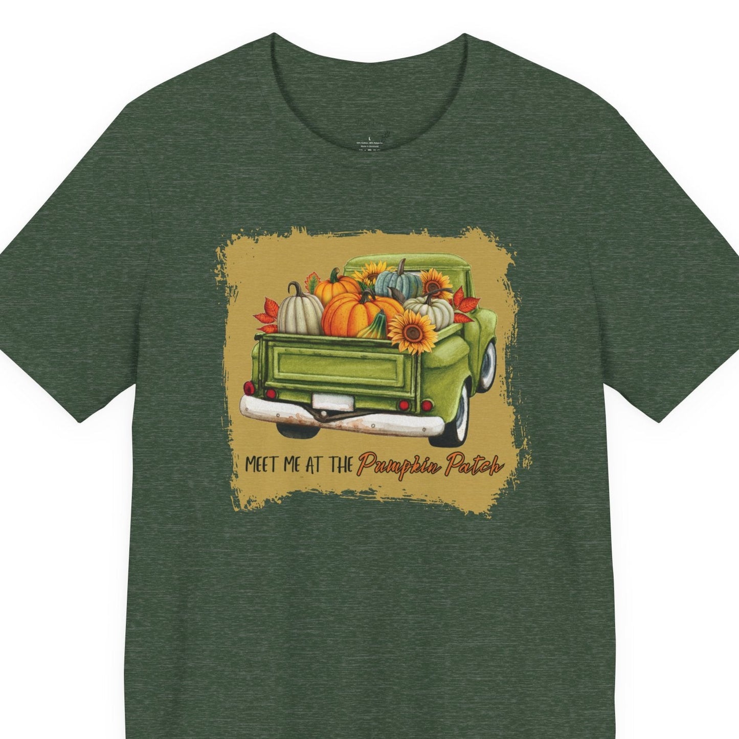 Green t-shirt with a graphic of a green truck carrying pumpkins and sunflowers, on a white background.