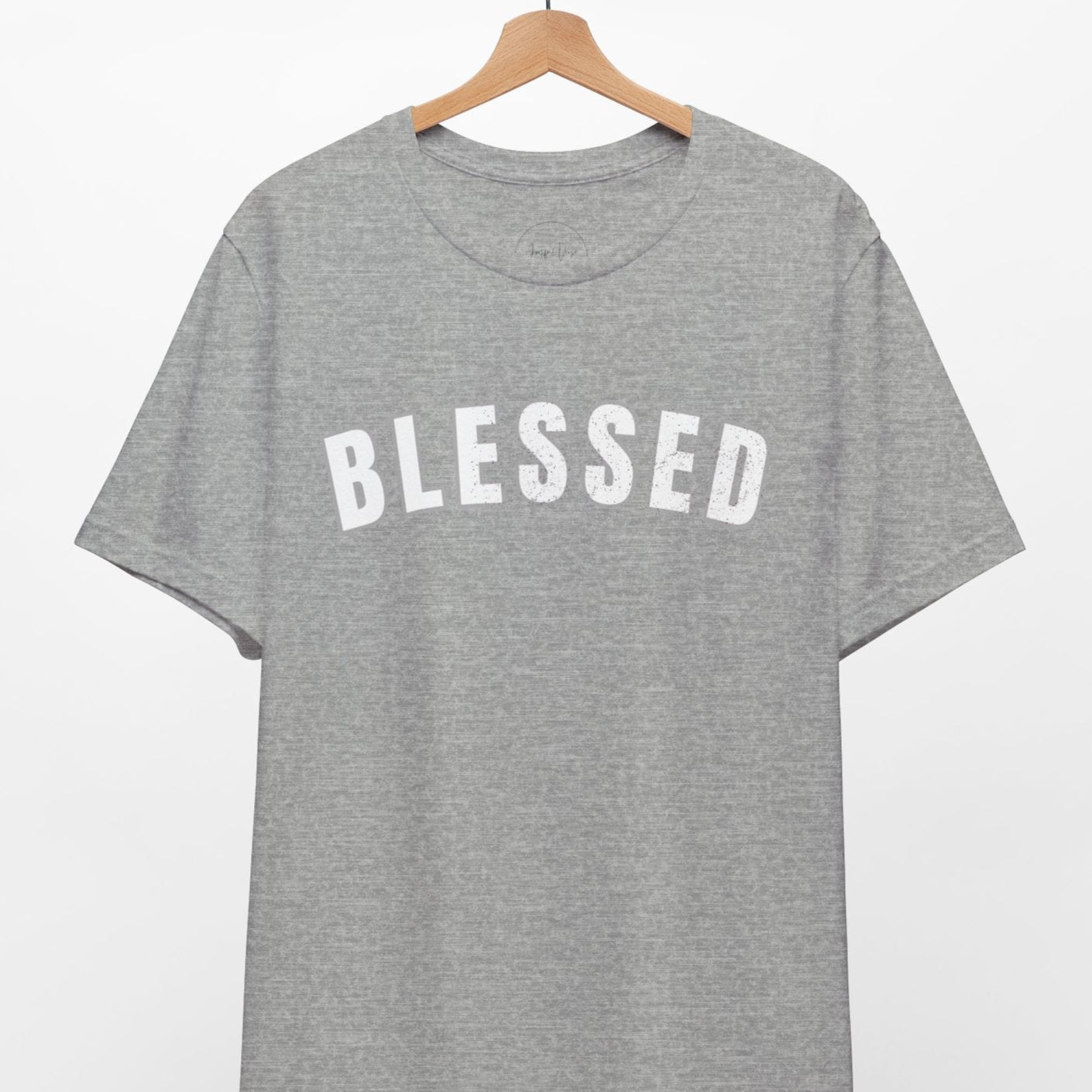 Gray t-shirt with 'BLESSED' text on a hanger against a white background