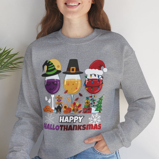 Person wearing a gray sweatshirt with 'Happy Hall-O-Thankismas' design, sitting on a white surface with a plant in the background.