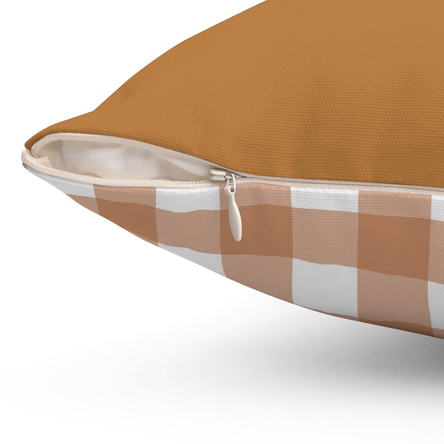 Close-up of brown fall pillow with white zipper and orange plaid backing, durable home accent design.