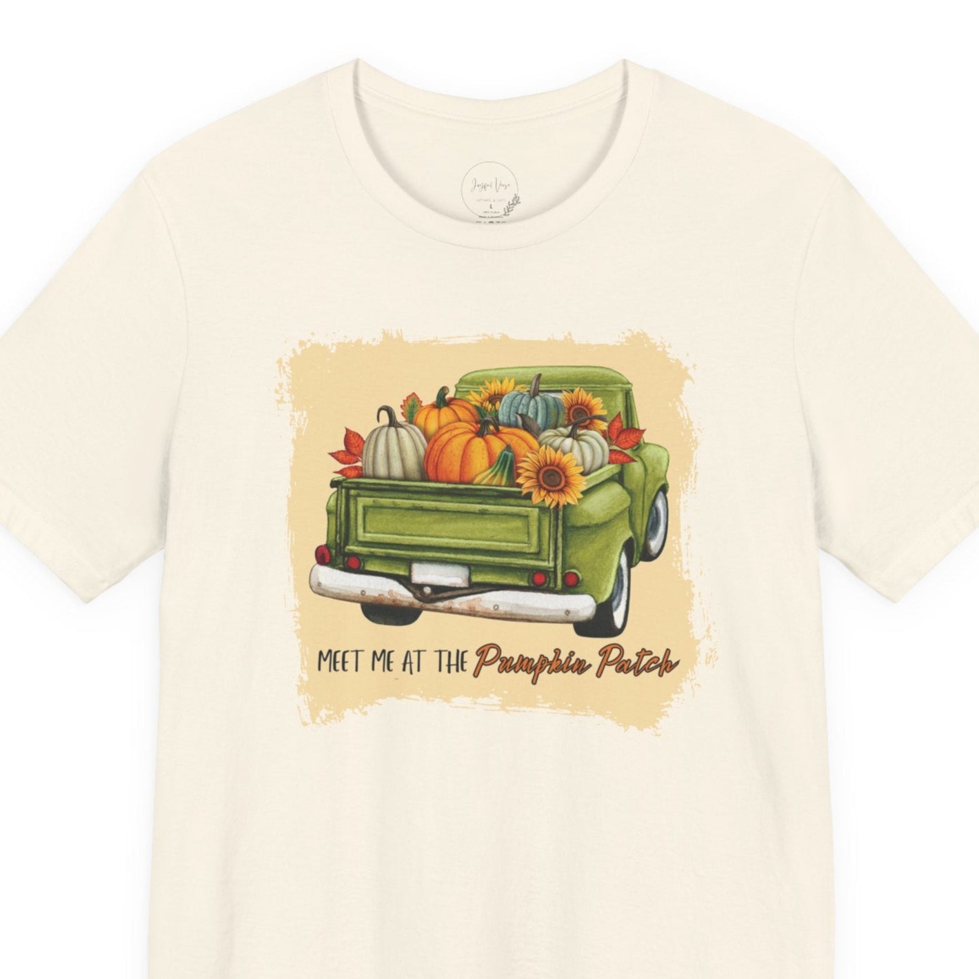 Beige t-shirt with a graphic of a green truck carrying pumpkins and flowers, with text 'Meet me at the Pumpkin Patch' on a white background.
