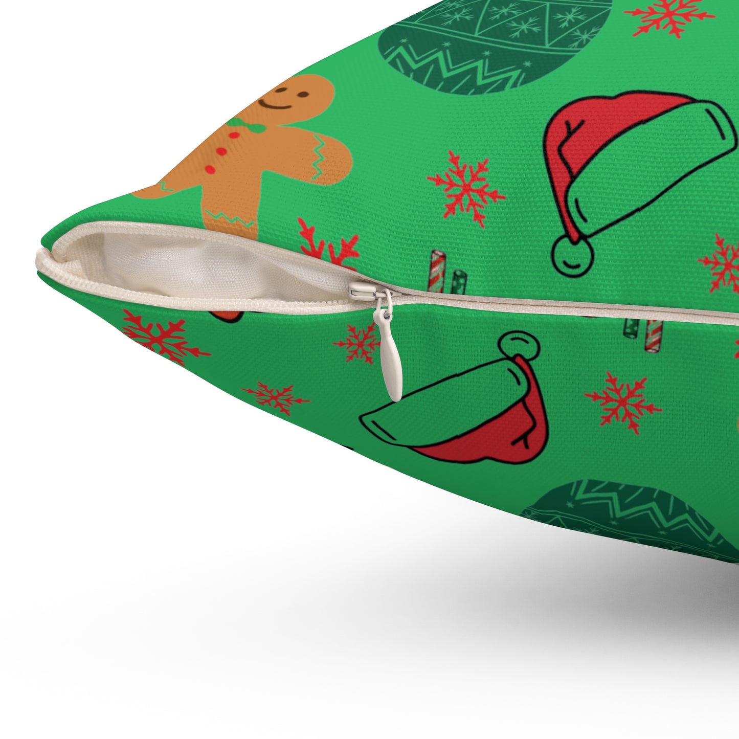 Green pillow with Christmas-themed designs including gingerbread men, Santa hats, and snowflakes on a white background. Close-up of the zipper