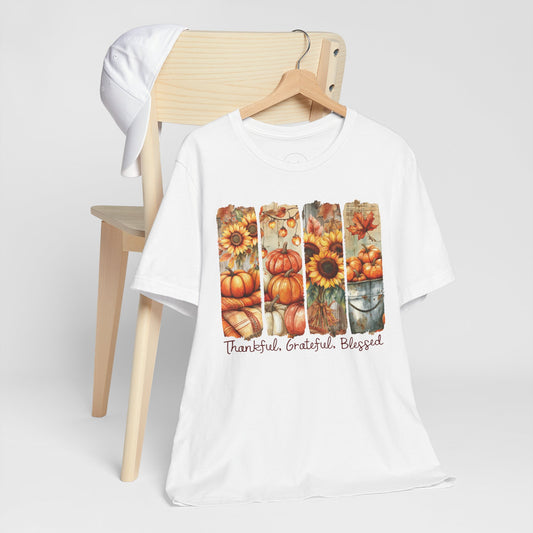 White t-shirt with autumn-themed design featuring pumpkins and sunflowers on a white background.