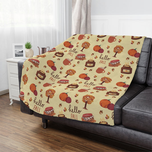 Decorative minky blanket with fall-themed pattern draped over a sofa in a living room.