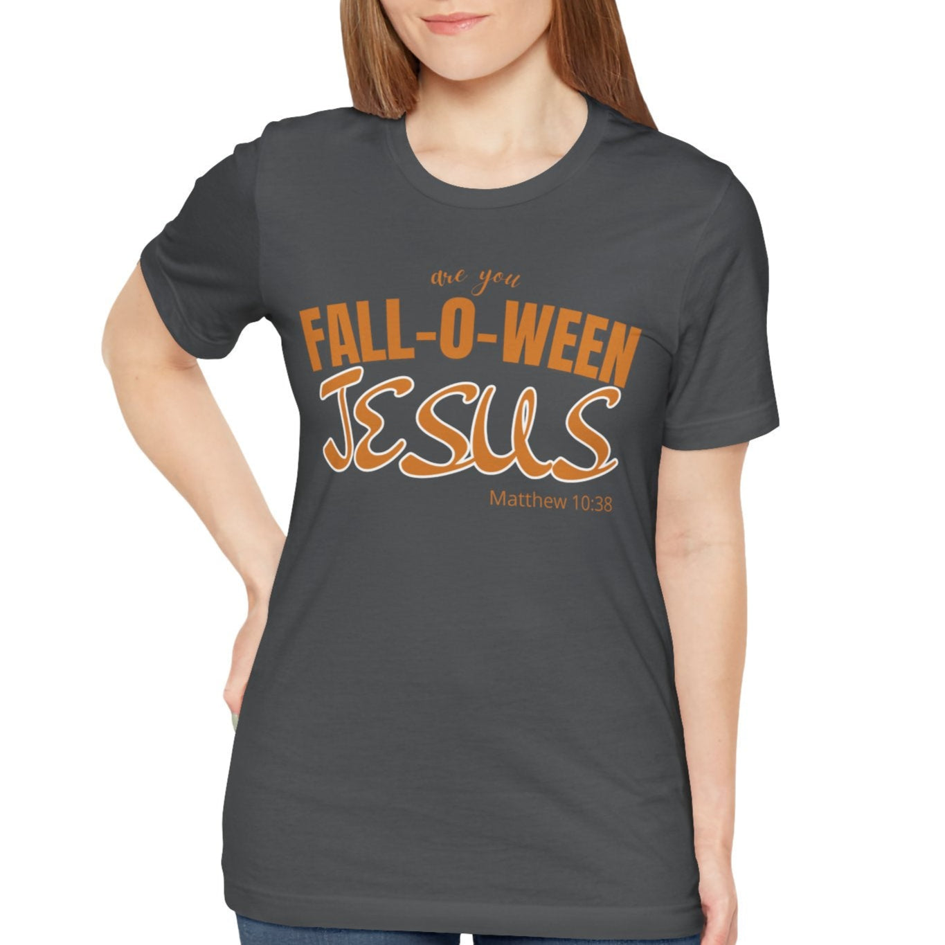 Woman wearing a dark gray t-shirt with 'Fall-o-Ween Jesus' text on a white background