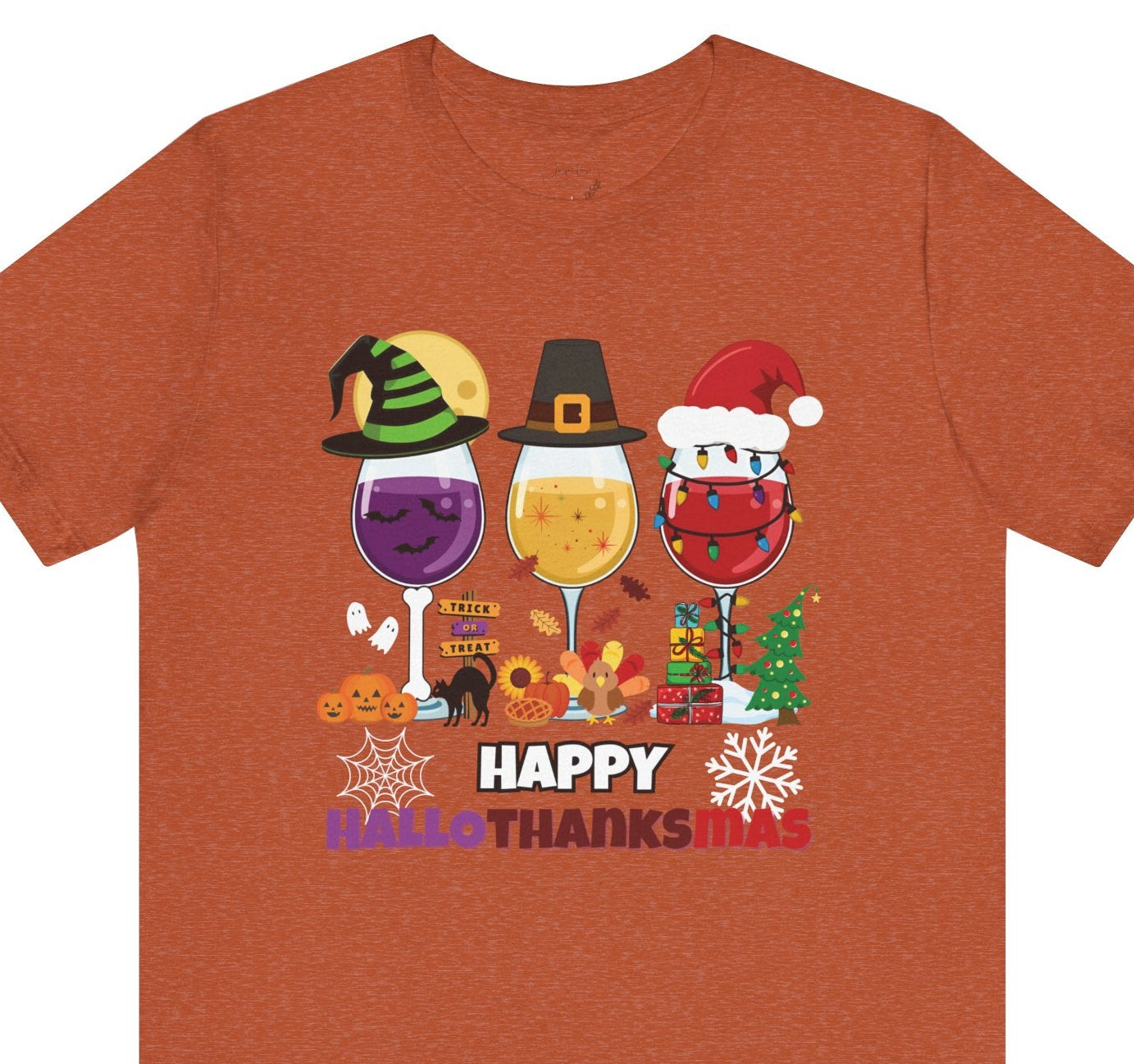 Brown t-shirt with 'Happy HalloThanks Mas' design featuring wine glasses and holiday-themed graphics on a white background.
