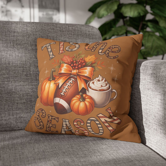 Decorative pillowcase with autumn-themed design featuring pumpkins, a football, and a coffee cup on a gray couch.