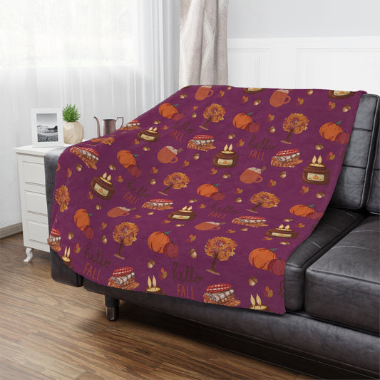 Burgundy fall-themed minky blanket draped over a gray sofa with pumpkin and pie pattern, cozy autumn home decor.