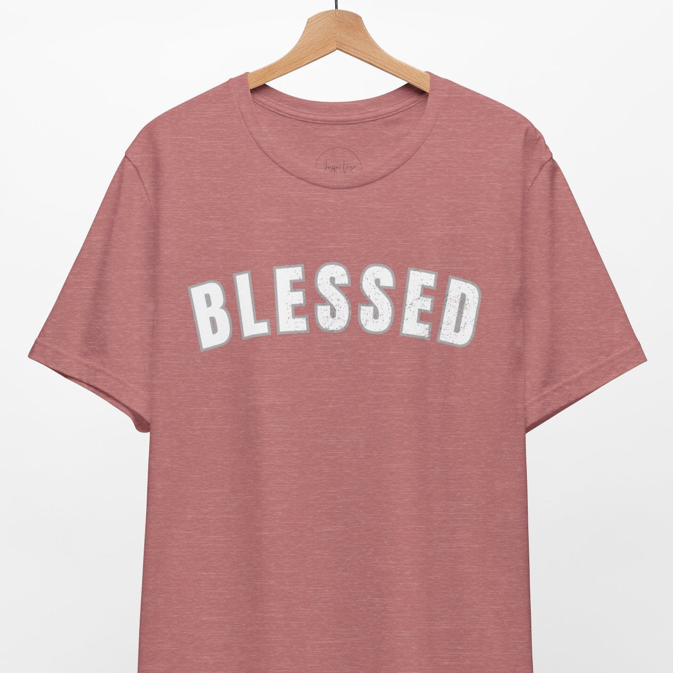 Mauve t-shirt with 'BLESSED' text on a hanger against a white background