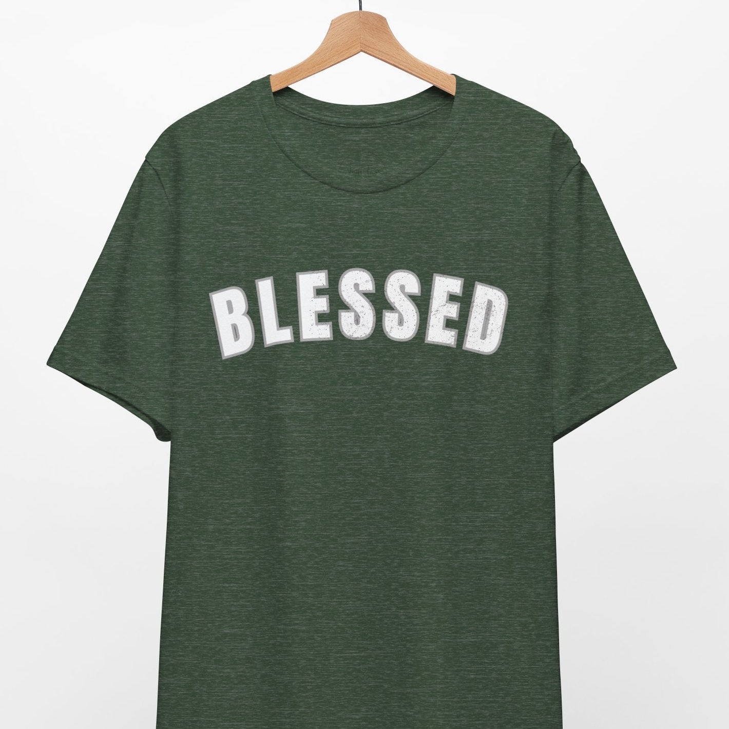 Green t-shirt with 'BLESSED' text on a hanger against a white background