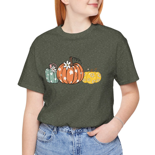 Person wearing a green t-shirt with pumpkin design on a white background