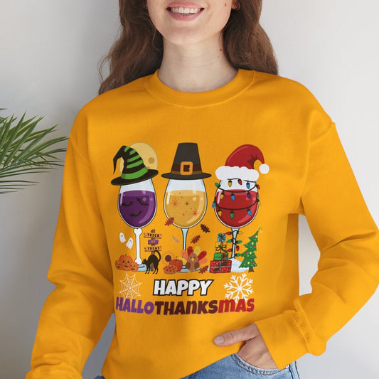 Woman wearing a yellow sweatshirt with 'Happy HalloThanksmas' design, sitting indoors.