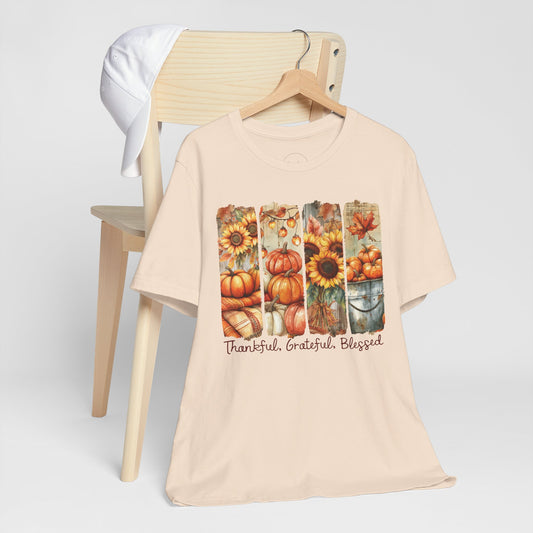 Beige t-shirt with autumn-themed design and text on a white background