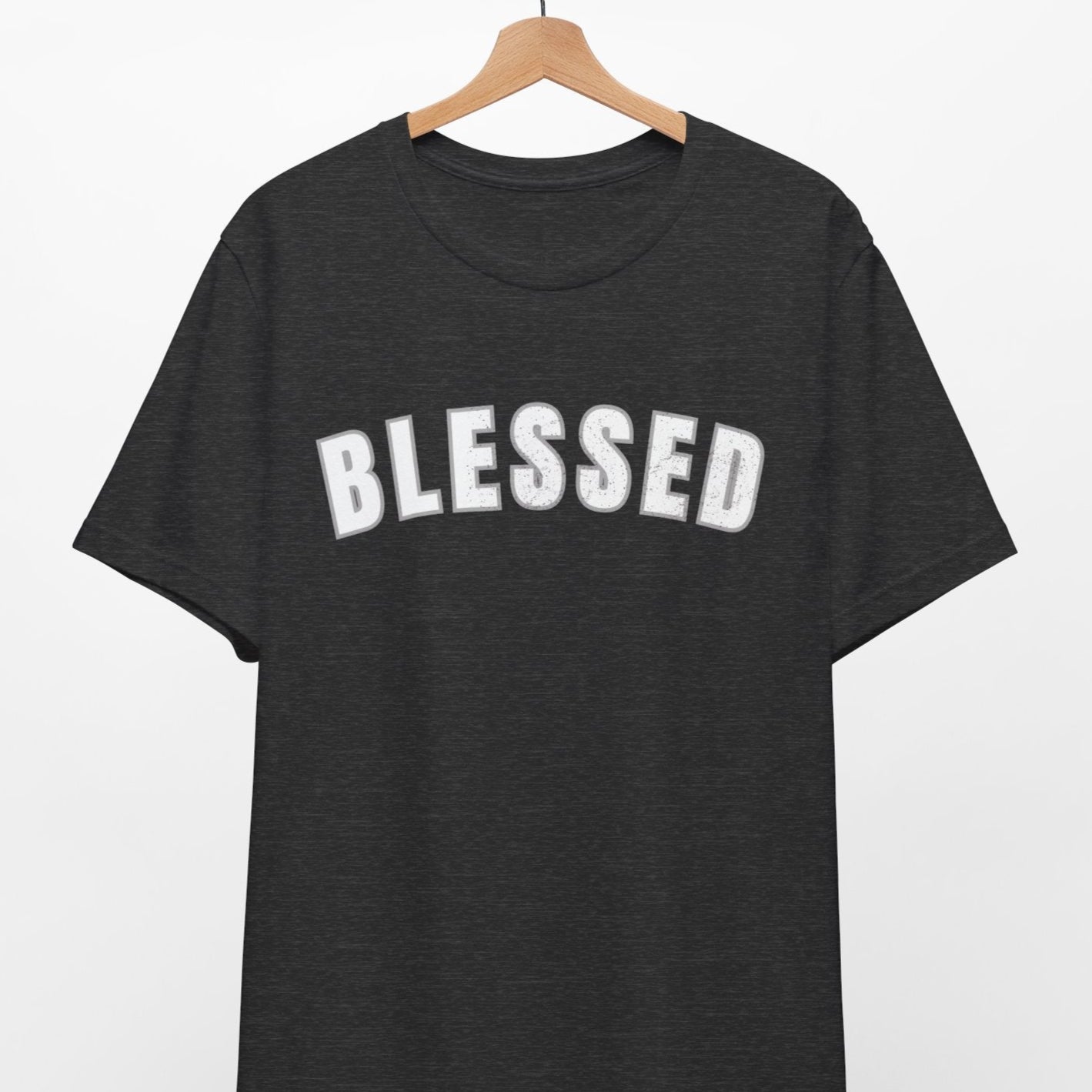 Black t-shirt with 'BLESSED' text on a hanger against a white background