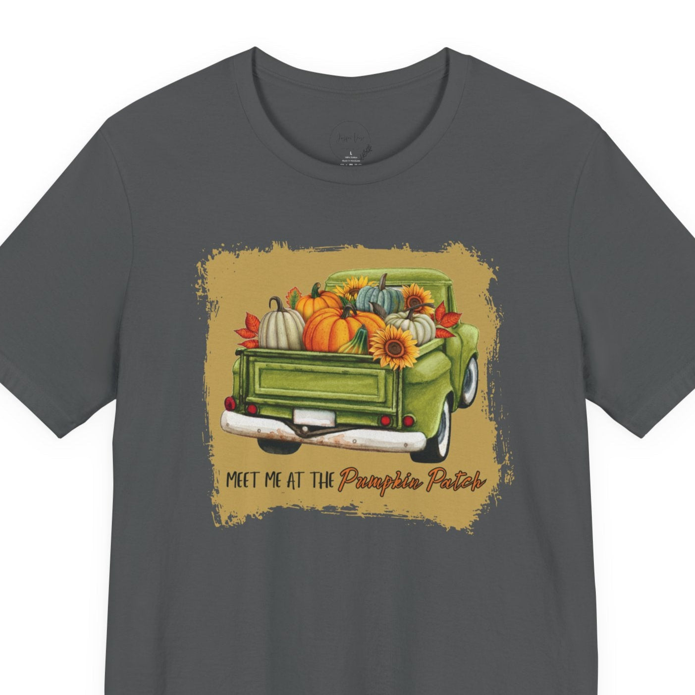 Gray t-shirt with a graphic of a green truck carrying pumpkins and sunflowers, with text 'Meet me at the Pumpkin Patch' on a beige background.