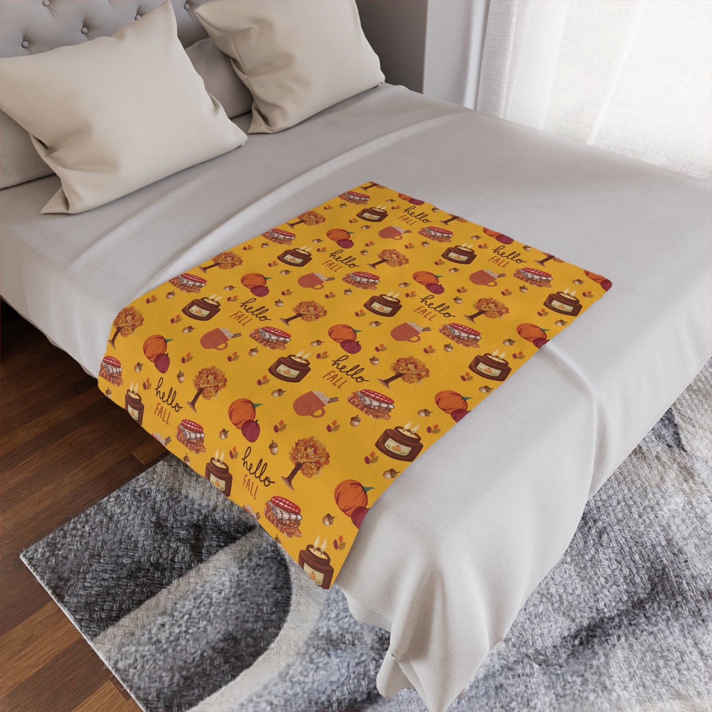 Bed with a yellow minky blanket featuring autumn-themed patterns and text.