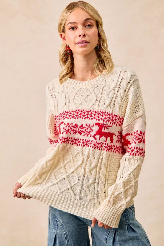 Christmas-themed cable knit sweater with festive red and white holiday pattern on a model.