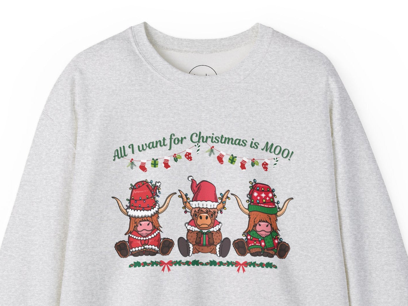 Grey sweatshirt featuring "All I Want for Christmas Is MOO" sweatshirt featuring three festive cows wearing Santa hats and scarves, printed on cozy crewneck sweaters in white and pink. Exclusive Joyful Verse design by Sara.