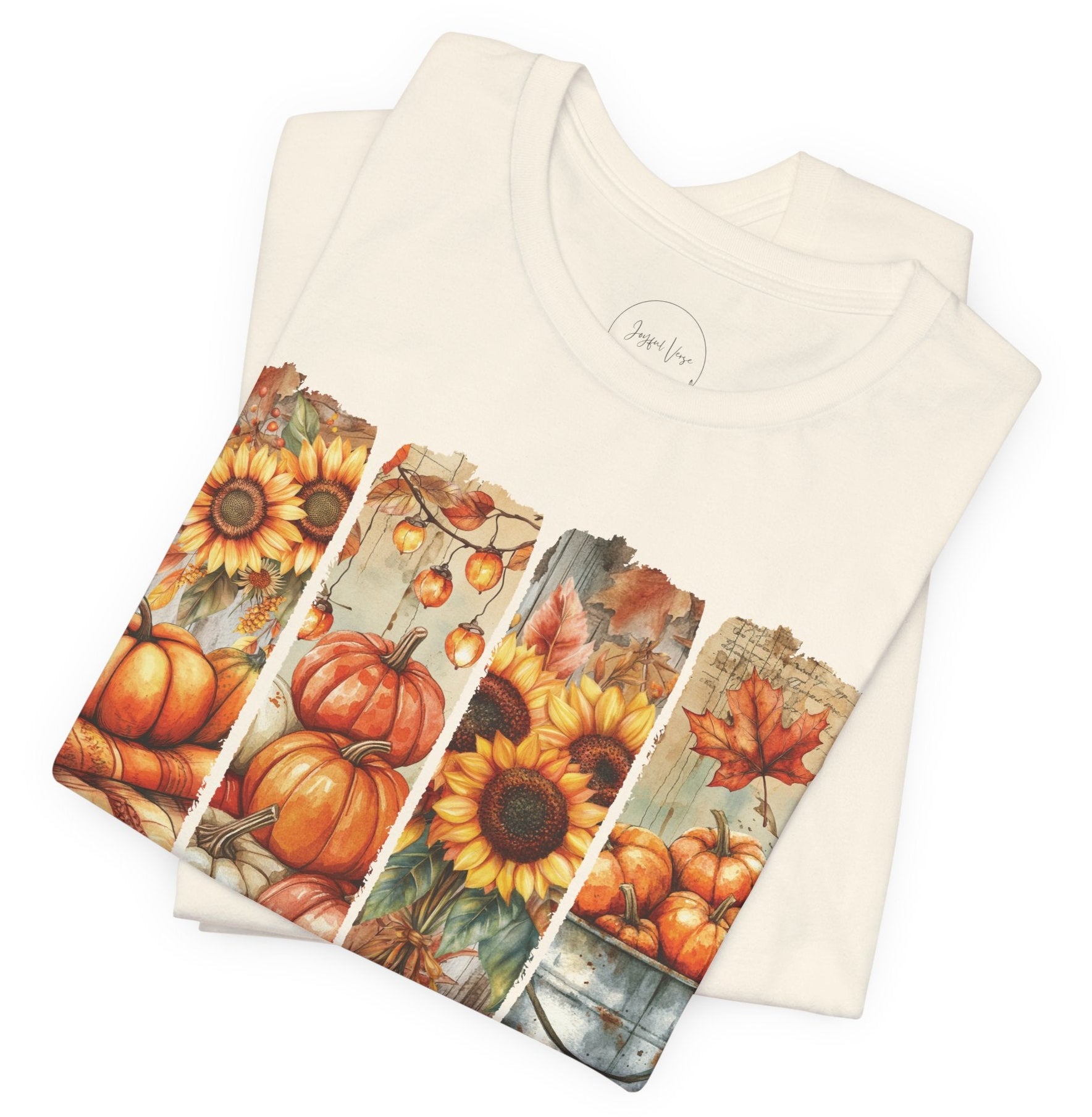 Folded beige t-shirt with autumn-themed design on a white background