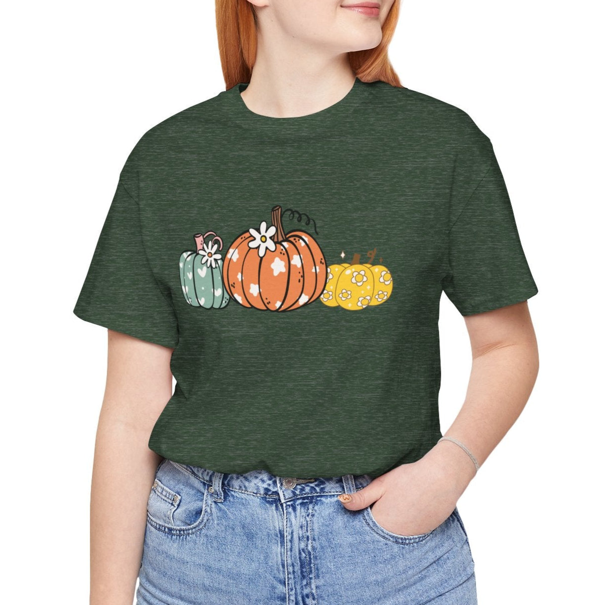 Person wearing a green t-shirt with pumpkin design on a white background