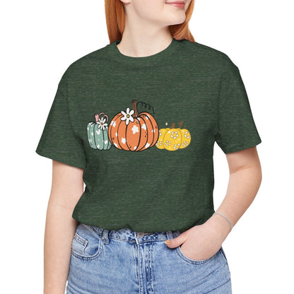 Person wearing a green t-shirt with pumpkin design on a white background