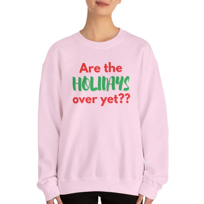 Person wearing a pink sweatshirt with text 'Are the holidays over yet??' on a white background
