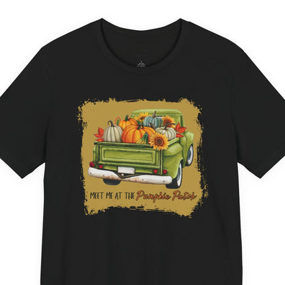 Black t-shirt with a graphic of a green truck carrying pumpkins and sunflowers, with text 'Meet me at the Pumpkin Patch' on a white background.