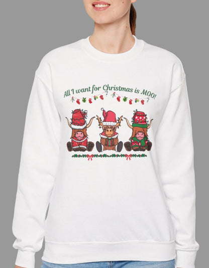 Woman wearing a white sweatshirt with "All I Want for Christmas Is MOO" sweatshirt featuring three festive cows wearing Santa hats and scarves, printed on cozy crewneck sweaters in white and pink. Exclusive Joyful Verse design by Sara.