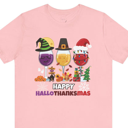 Pink t-shirt with 'Happy Hallothanksmas' design featuring wine glasses and holiday elements on a white background.