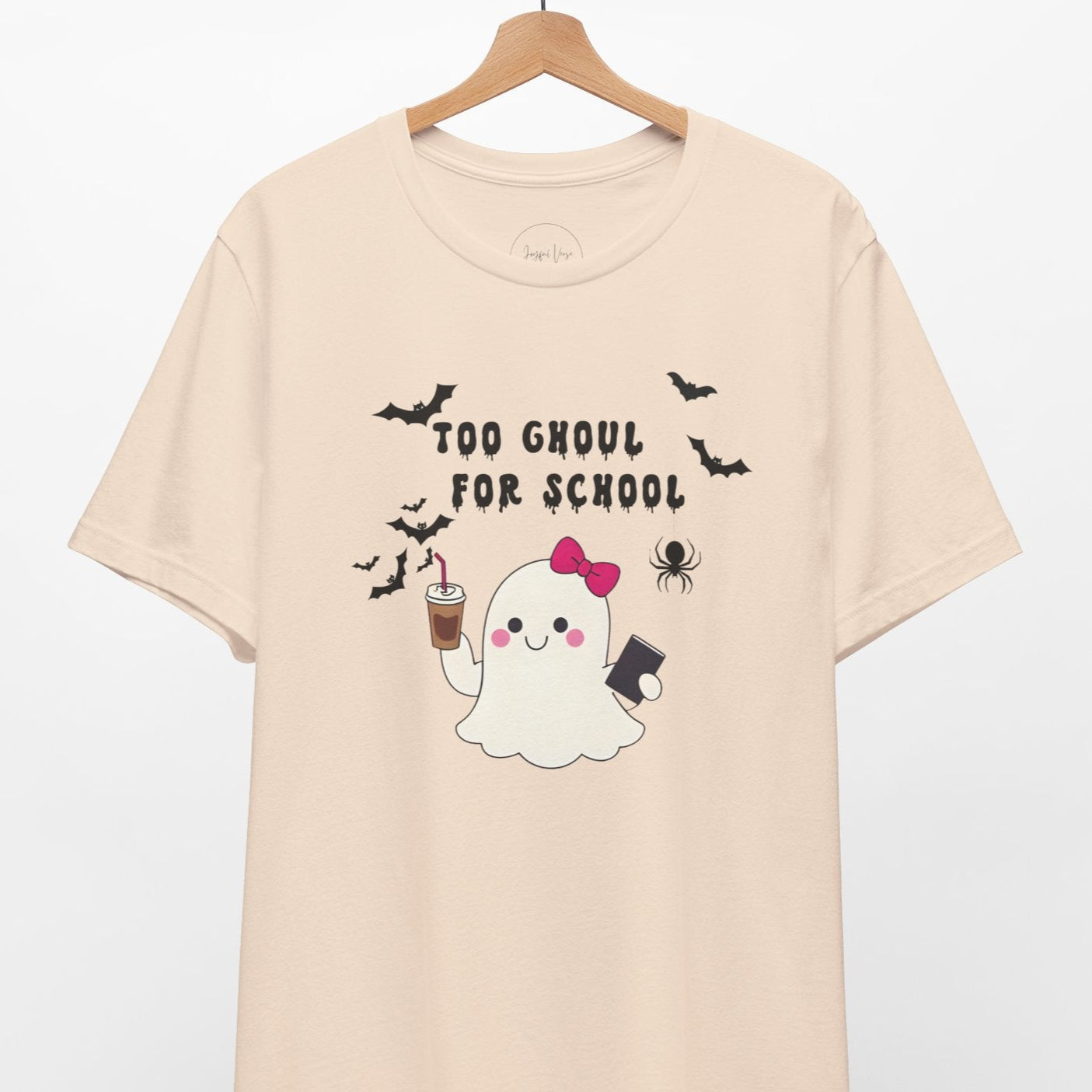 Beige t-shirt with a ghost graphic and text 'Too Ghoul for School' on a hanger against a white background