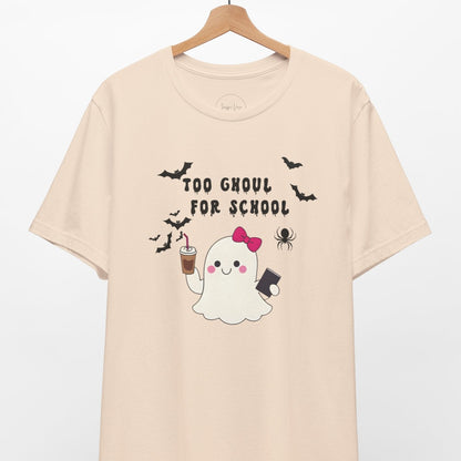 Beige t-shirt with a ghost graphic and text 'Too Ghoul for School' on a hanger against a white background