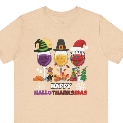 Beige t-shirt with 'Happy Hallothanksmas' design featuring wine glasses and holiday-themed graphics on a white background.