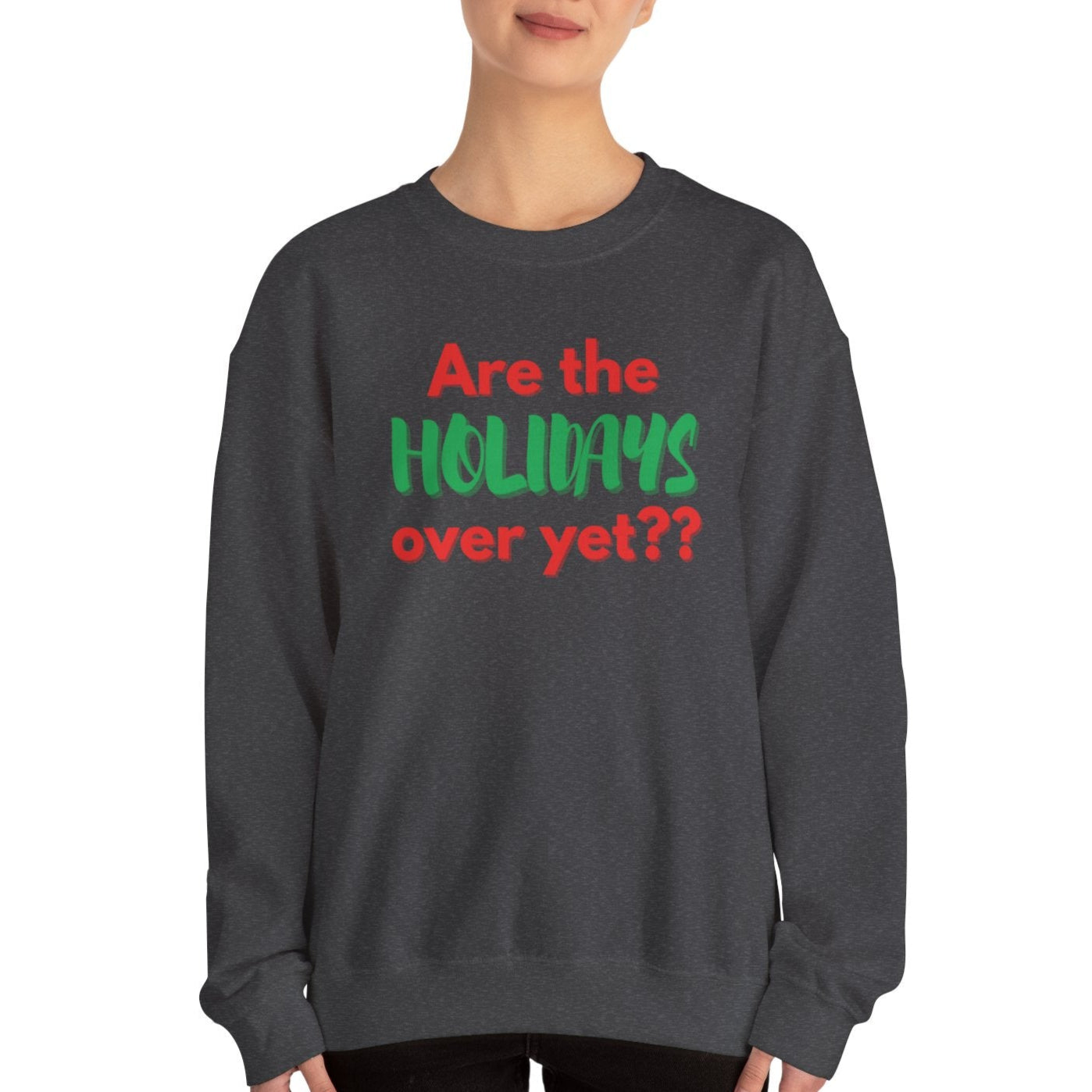 Person wearing a dark gray sweatshirt with the words "Are the holidays over yet?" on a white background