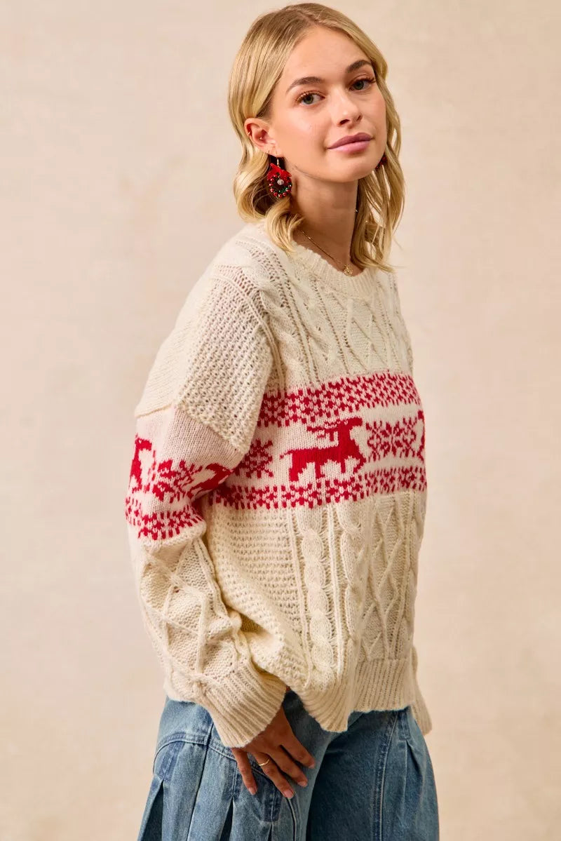 Christmas-themed cable knit sweater with festive red and white holiday pattern on a female model.