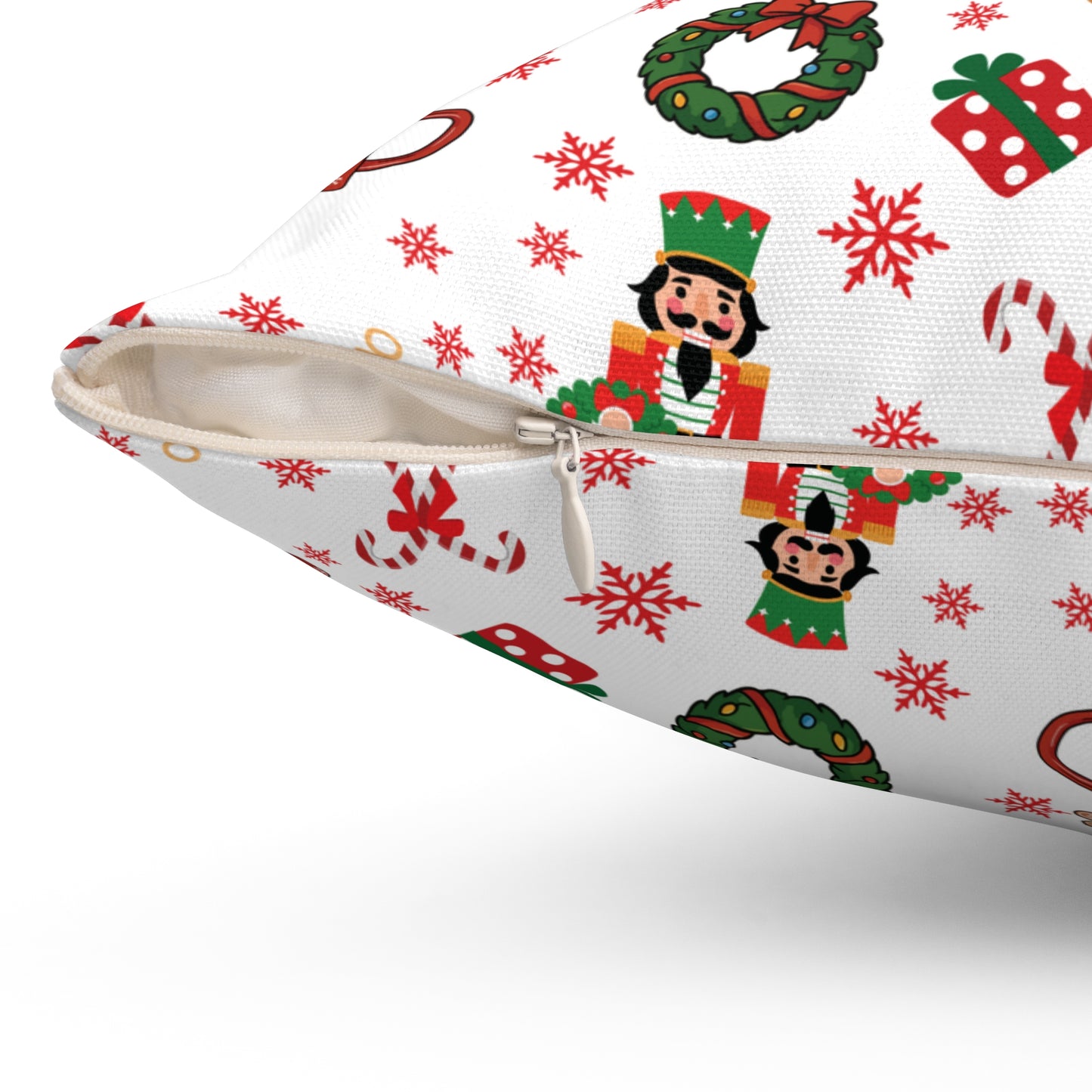 Closeup picture of a zipper on a pillow with Christmas-themed design featuring nutcrackers, wreaths, and snowflakes on a white background.