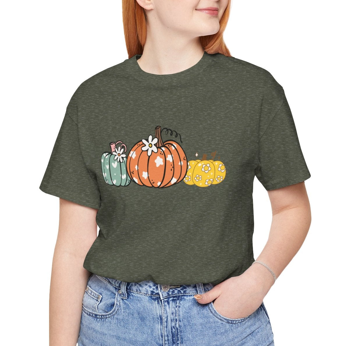 Person wearing a green t-shirt with pumpkin design on a white background