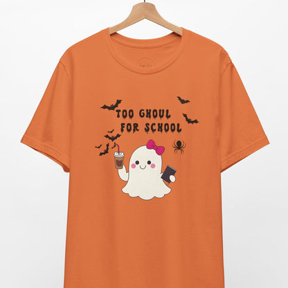 Orange t-shirt with Halloween-themed design featuring a ghost and text on a hanger against a white background.