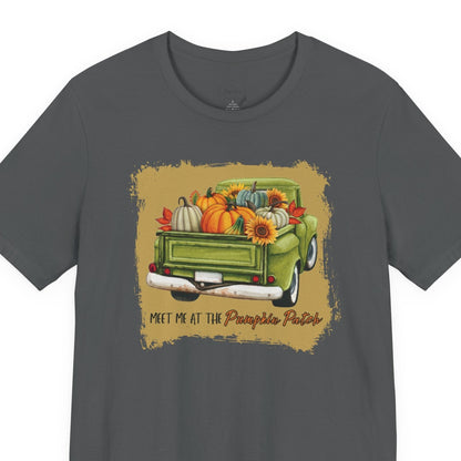 Gray t-shirt with a graphic of a green truck carrying pumpkins and sunflowers, with text 'Meet me at the Pumpkin Patch' on a beige background.