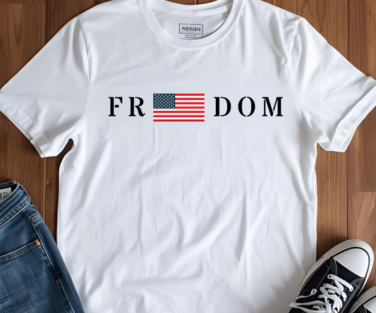 White t-shirt with 'FR DOM' and American flag design, paired with jeans and sneakers on a wooden floor.
